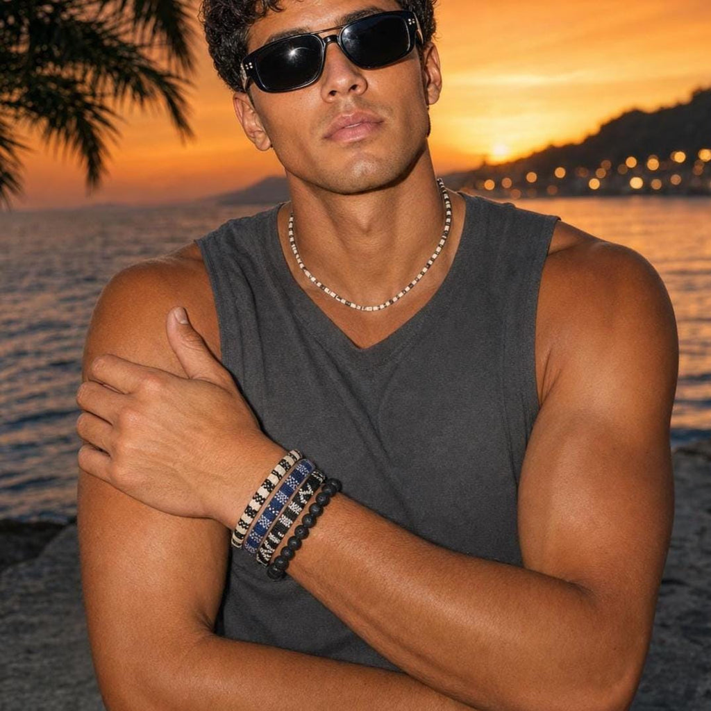May include: A set of four bracelets worn on the wrist, including three beaded bracelets with intricate blue, white, and black geometric patterns and one solid black matte beaded bracelet, paired with a matching beaded necklace in white and black.